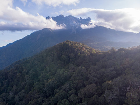 Aerial drone image of misty foggy and cloud with green nature rainforest jungle and Mount Kinabalu of Sabah, Borneo