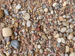 Stones of different colors. Coarse texture. Material for construction. Cobblestones of different sizes.