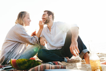 Lovely young couple having a picnic at the beach