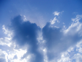 Obraz premium Clouds like a heart and rays of the sun breaking through them. Symbol of love in the sky.