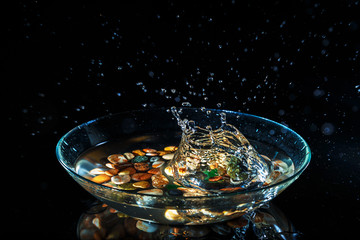 Water splashes on a black background. The stone drops water and creates splashes. Frozen motion.