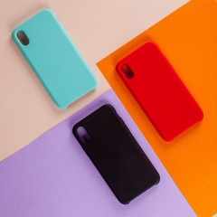 Cell phone cases various colors on multicolor paper background
