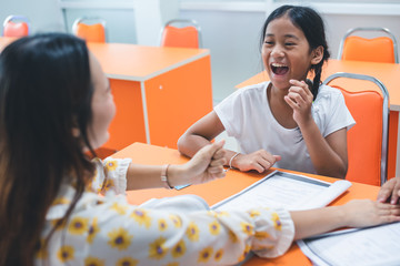 Asian elementary school girl is studying and having fun in the classroom with female teachers.