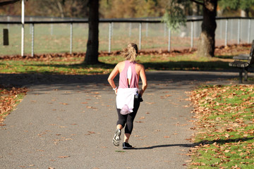 Female runner on the path at a park on a sunny day.