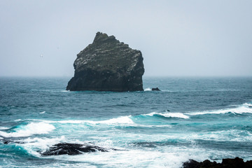 Big rock in the ocean just outside the icelandic coastline in the south. Popular, visit, place and travel concept.