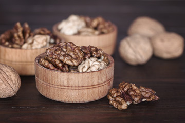 walnuts closeup. peeled walnuts in wooden bowls close-up on the table. background with walnuts.
