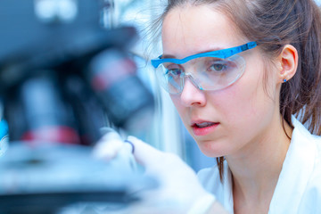 Laboratory assistant uses a polarizing microscope in a microbiological laboratory