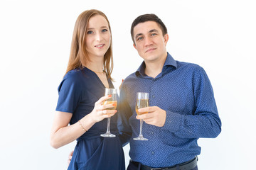 Man and woman celebrating Christmas or New Year eve party with glasses of champagne on white background