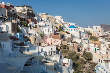 Fototapeta na wymiar View over the buildings in the cliffside of Oia, Santorini. Architecture, buildings, houses, culture, travel, europe concept.