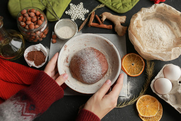 The process of making christmas cookies. Girl hands make the dough. Ingredients for baking a pie: flour, confectionery, dishes, kitchen utensils, spruce cookies figure on a dark background.Christmas g