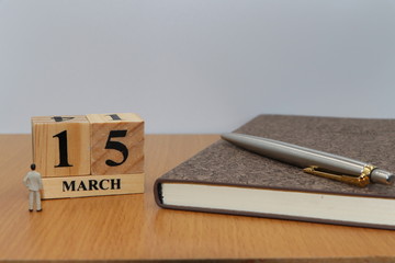 March  15, a calendar photo from the wood The table top consists of a book and pen that is ready to use. White background