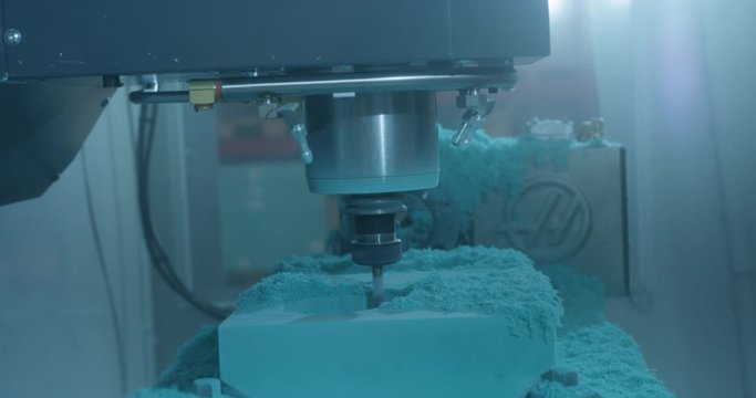 CNC machinery carving circular pattern with flying debris in modern manufacturing plant factory