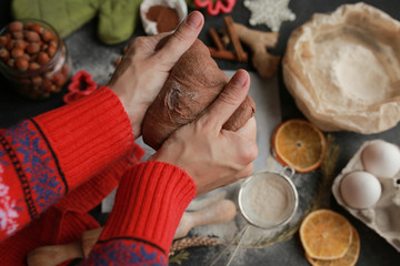 Obraz na płótnie Canvas The process of making christmas cookies. Girl hands make the dough. Ingredients for baking a pie: flour, confectionery, dishes, kitchen utensils, spruce cookies figure on a dark background.Christmas g
