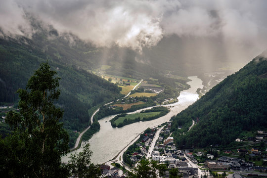Rainy weather and sun beams over the city of Otta in Gudbrandsdalen/Norway. Fjords, sun beams, rainy, nature, landscape concept.