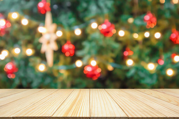 Empty wood table top with Abstract blur Christmas tree with decoration bokeh light background for...