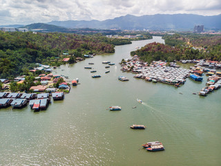 Fototapeta na wymiar Top down aerial view of the water village houses in a small village Beside river at Sabah, Borneo