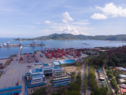 Aerial Image of Logistics and transportation of Container Cargo ship and Cargo plane with working crane bridge in shipyard in Sabah Port, Malaysia