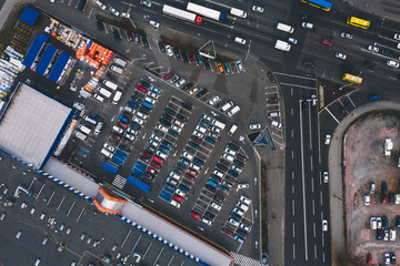 Car parking in asphalt parking lot near supermarket and car track. Outdoor parking lot with different venicles. Parking concept.