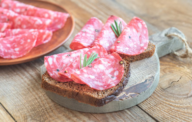 Sandwiches with salami on the wooden board