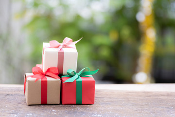 Christmas gift box with ribbon on wood background