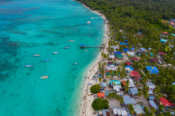 Aerial drone image of beautiful white sandy beach tropical island with turquoise sea water and Malay traditional fisherman village at Mantanani Island, Sabah, Borneo - Travel Concept