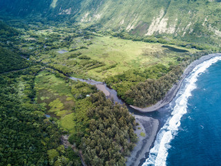 Aerial drone shot view of bridge over a river flows into pacific ocean on big island in Hawaii