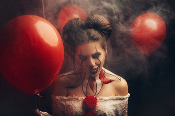 Creepy beautiful woman in the image of a scary clown. Carnival outfit white dress with red buboes....
