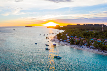 Aerial drone image of beautiful white sandy beach tropical island with turquoise sea water and Malay traditional fisherman village at Mantanani Island, Sabah, Borneo - Travel Concept