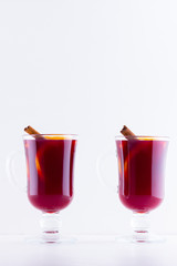 Glass of hot mulled wine with spices on white background. Christmas mulled wine with orange, star anise and cinnamon. Two glasses of winter Christmas drink