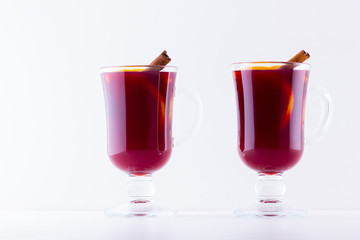 Glass of hot mulled wine with spices on white background. Christmas mulled wine with orange, star...