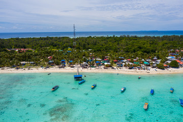 Fototapeta na wymiar Aerial drone image of beautiful white sandy beach tropical island with turquoise sea water and Malay traditional fisherman village at Mantanani Island, Sabah, Borneo - Travel Concept