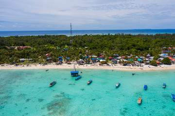 Obraz premium Aerial drone image of beautiful white sandy beach tropical island with turquoise sea water and Malay traditional fisherman village at Mantanani Island, Sabah, Borneo - Travel Concept