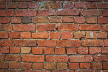 Fototapeta premium Red brick wall close-up. The laying of stones. Background texture for the site. Construction of the wall of quality materials.