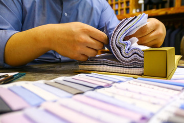 tailor choosing a fabric in swatch for his customer