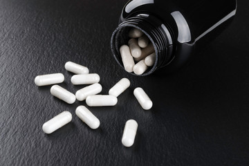 food supplement capsules on black background closeup
