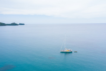 Obraz na płótnie Canvas Aerial view of white Yacht in deep blue sea with beautiful landscape view in Kudat, Sabah, Borneo