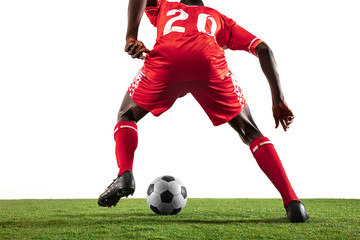 Professional african-american football or soccer player of red team in motion isolated on white studio background. Fit man in action, excitement, emotional moment. Concept of movement at gameplay.