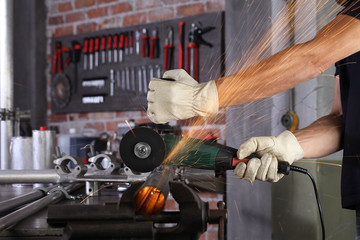 hands man work in home workshop garage cut metal pipe, with construction gloves, cutting metal...