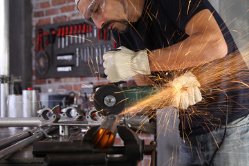 man work in home workshop garage cut metal pipe, goggles and construction gloves, cutting metal...