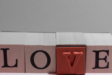 Love letters on wooden cubes with neutral space as background.