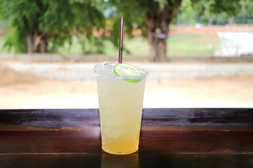 Honey lemon juice, cool and sweet, placed on a wooden table.