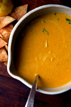 Lemon, carrot and tahini soup served in bowl with pita crisps
