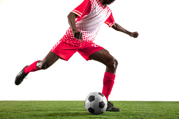 Professional african-american football or soccer player of red team in motion isolated on white studio background. Fit man in action, excitement, emotional moment. Concept of movement at gameplay.