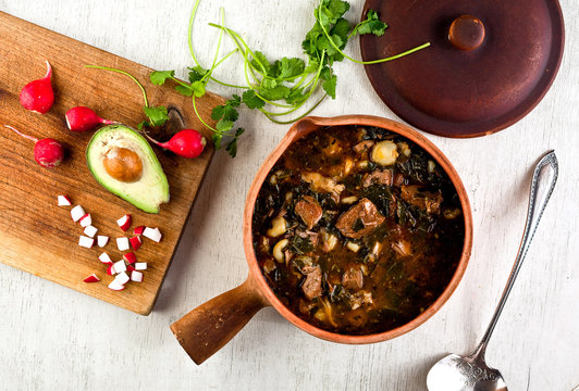 Spicy pork and hominy stew with collard greens