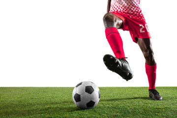 Professional african-american football or soccer player of red team in motion isolated on white studio background. Fit man in action, excitement, emotional moment. Concept of movement at gameplay.