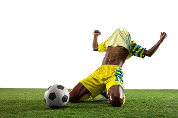 Professional african-american football or soccer player of yellow team in motion isolated on white studio background. Fit man in action, excitement, emotional moment. Concept of movement at gameplay.