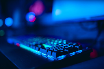 Fototapeta na wymiar Blurred background computer, keyboard, blue and red lights. Concept eSports arena for gamer playing tournaments