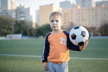 my mother's boy plays football on the football field gives a pass hits the ball runs across the field and scores a goal sports child soccer player trains in the fresh air