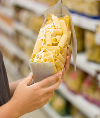 Female hand choosing pasta in supermarket