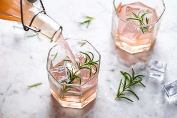 Pink grapefruit and rosemary drink, backlight on white background